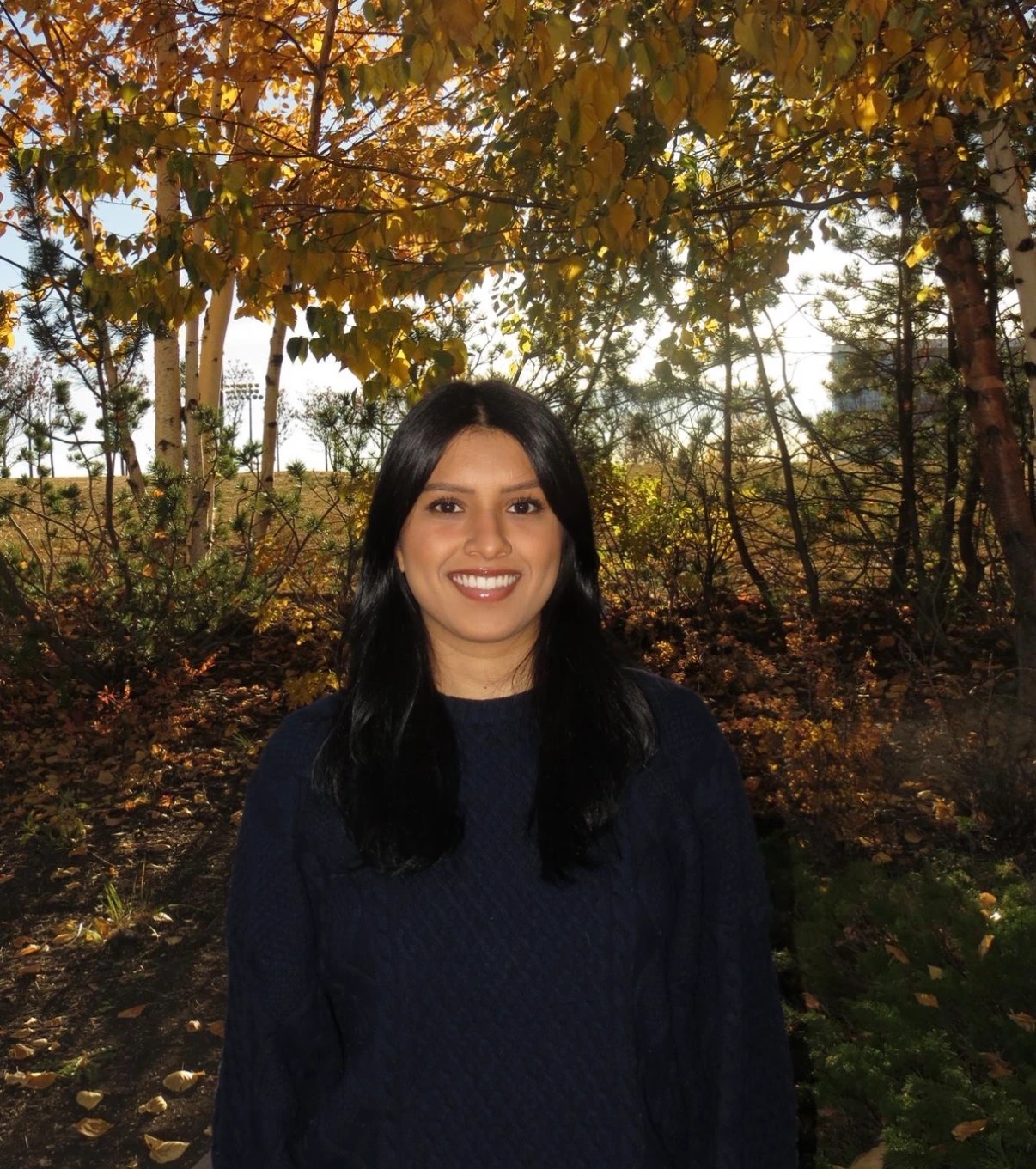Sanchia in front of trees with autumn foliage